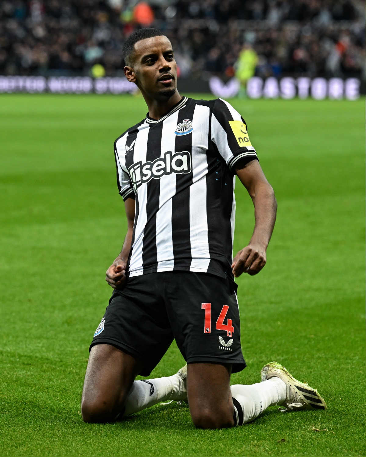 Alexander Isak celebrates scoring at St. James' Park with a knee slide.